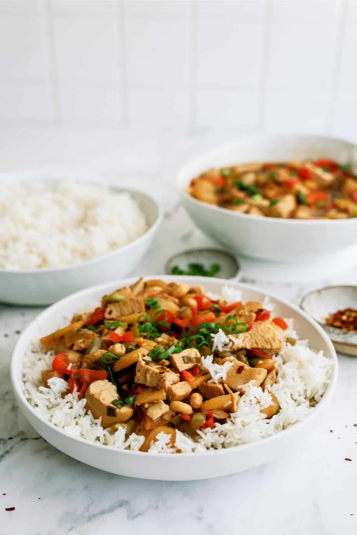 Slow Cooker Kung Pao Chicken in a white bowl served over rice