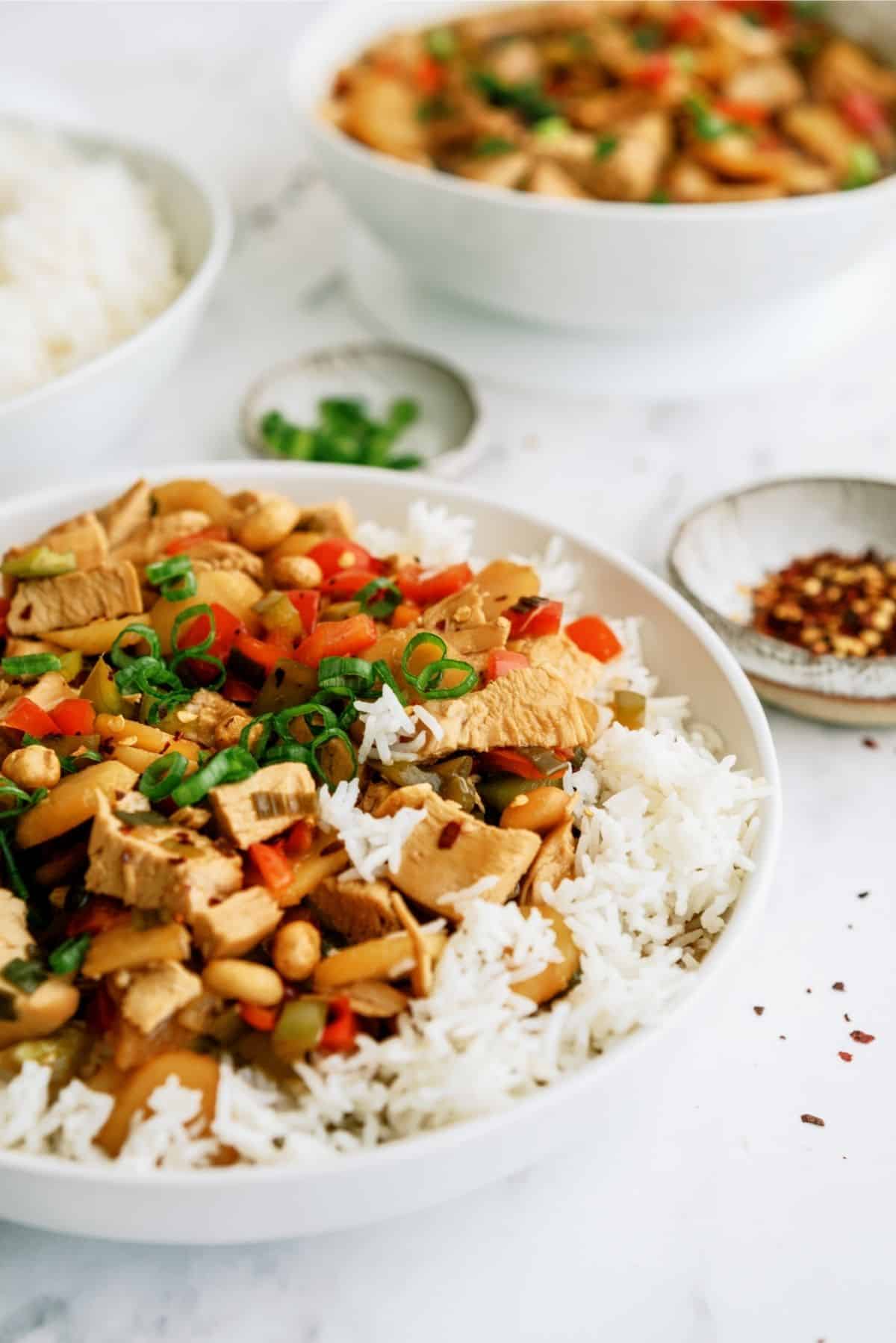 Slow Cooker Kung Pao Chicken served over rice in white bowl