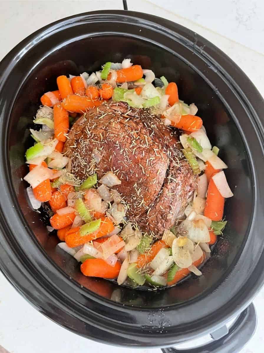 the perfect pot roast ready to cook in the slow cooker