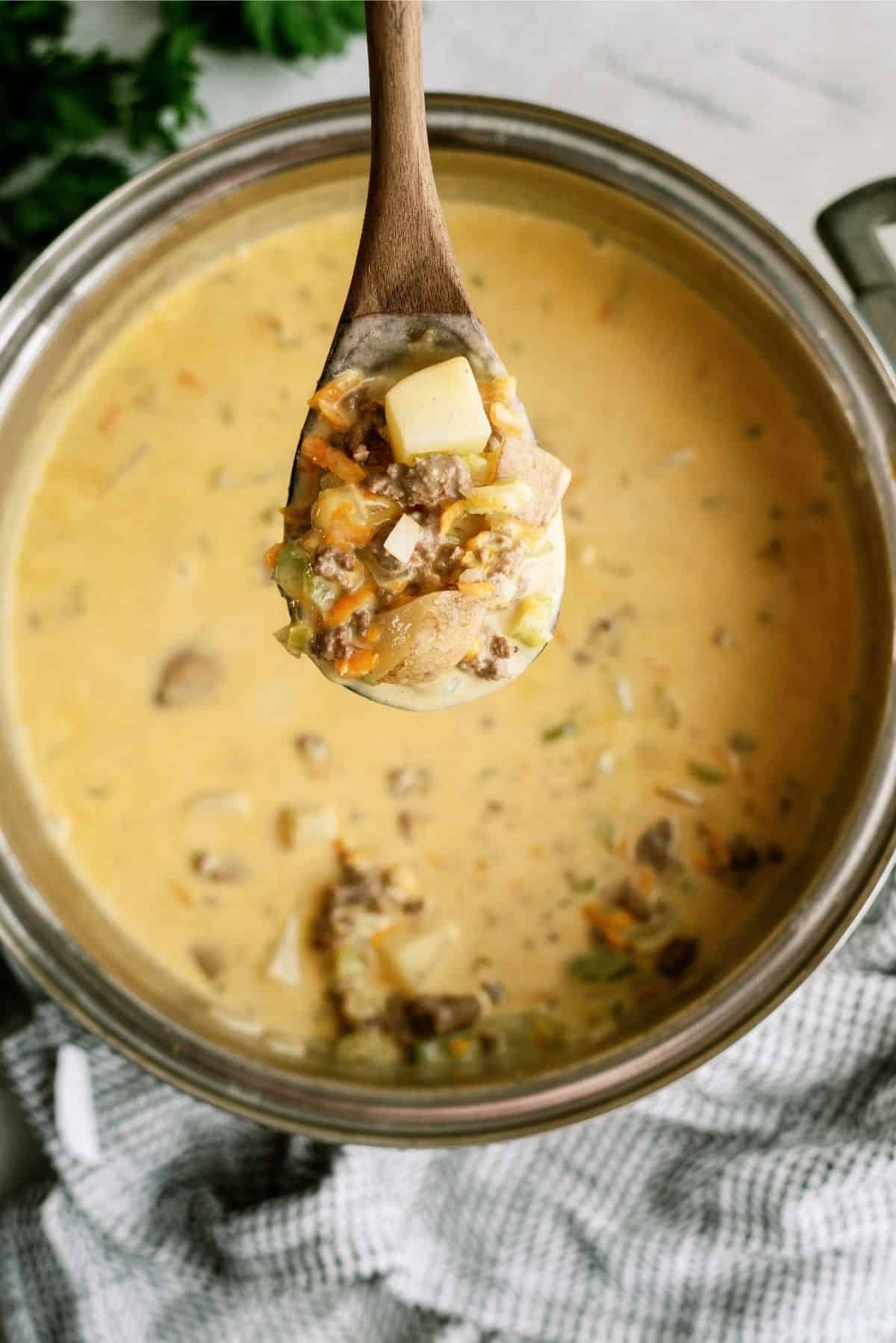 Wooden Spoon over Sauce Pan full of Cheeseburger Soup