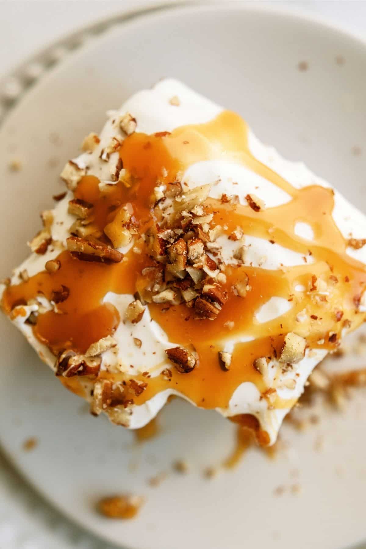 Slice of Caramel Pumpkin Poke Cake on a white plate