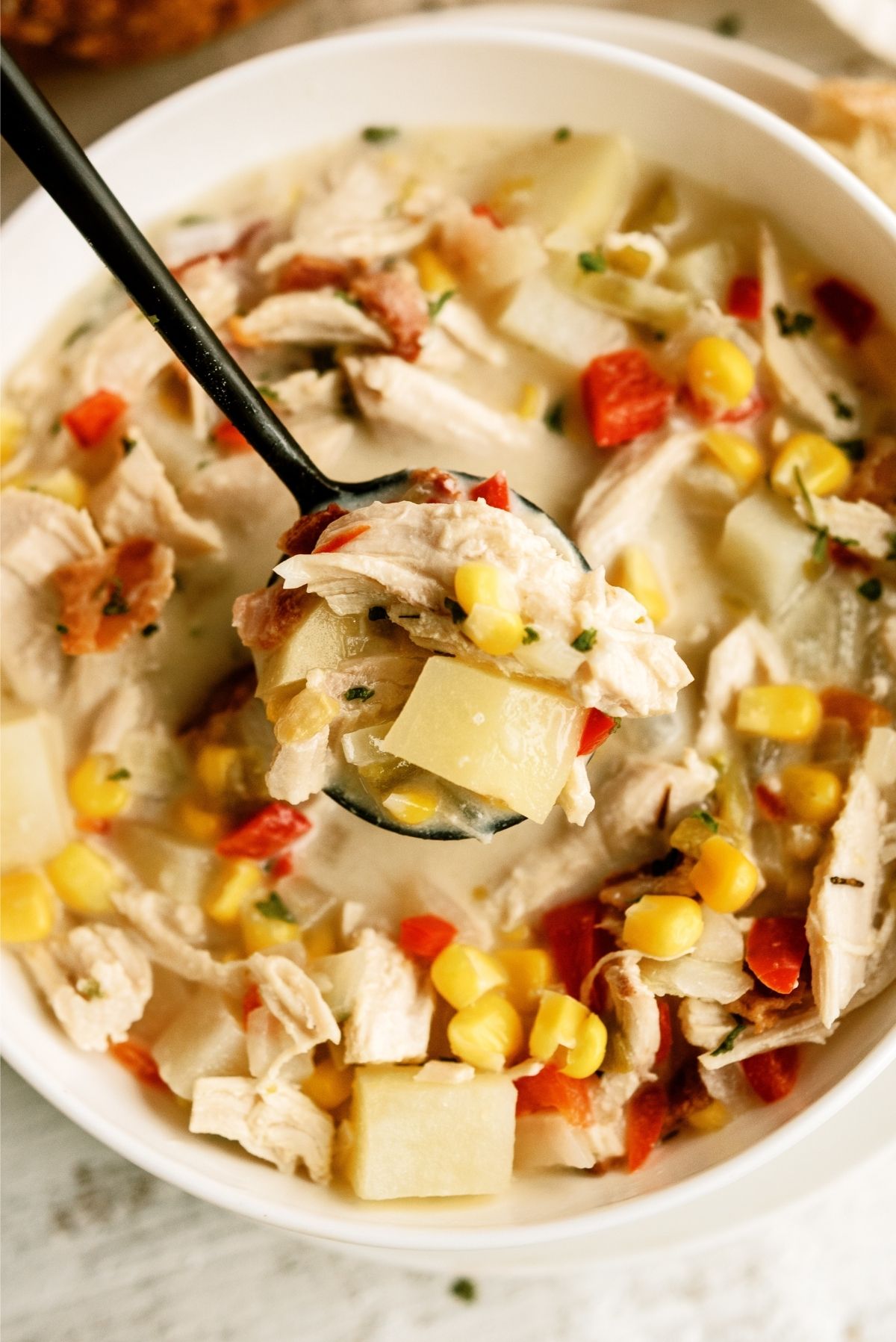 Chicken Corn Chowder in a white bowl with a spoon