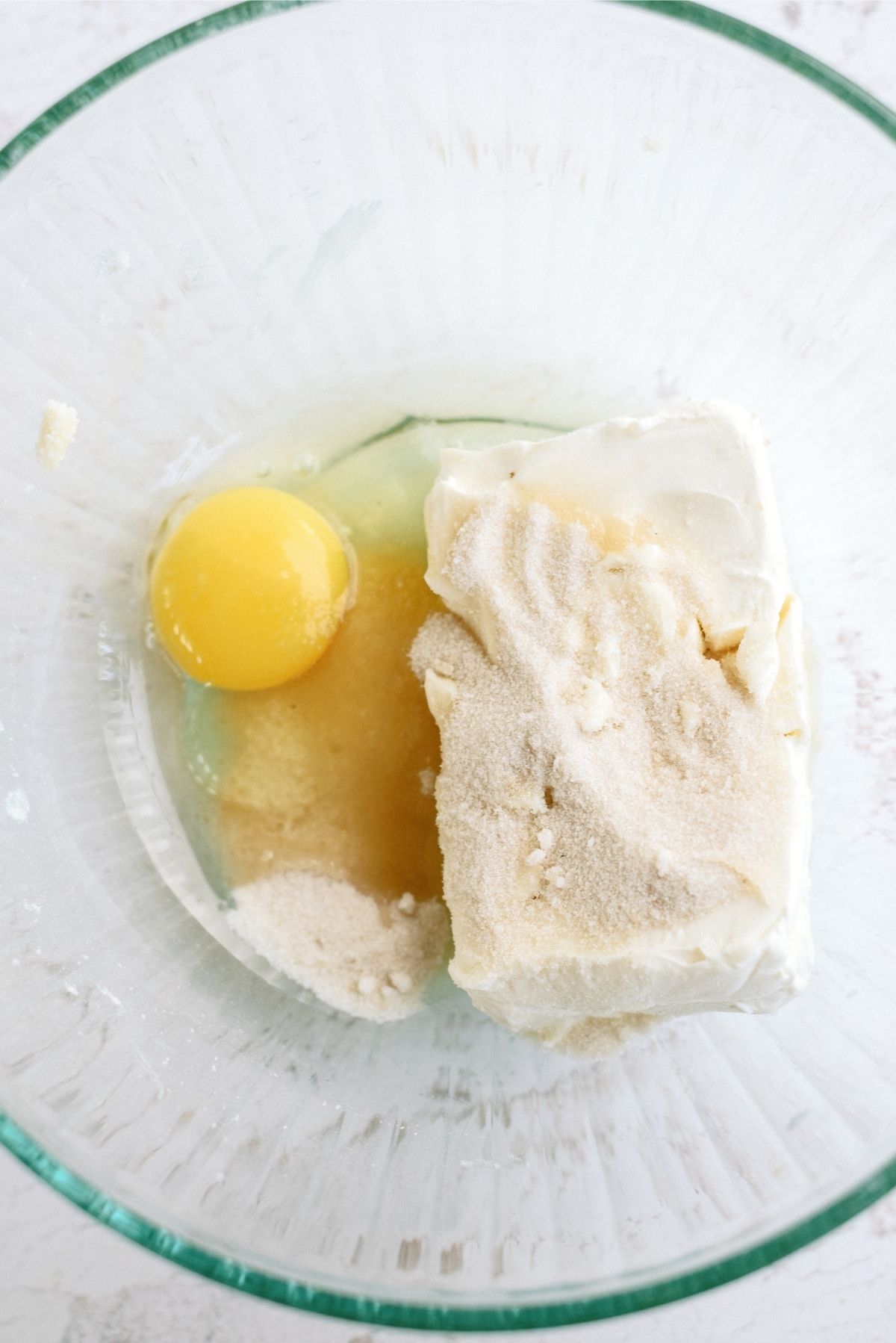 Glass bowl with cream cheese, egg, and sugar