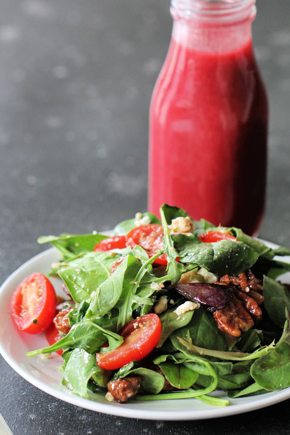 California Salad on a plate with a bottle of homemade Raspberry Vinaigrette Dressing
