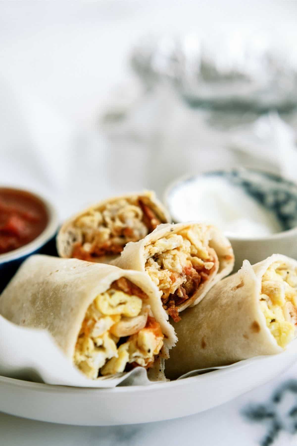 Freezer Breakfast Burritos on a plate with salsa and sour cream