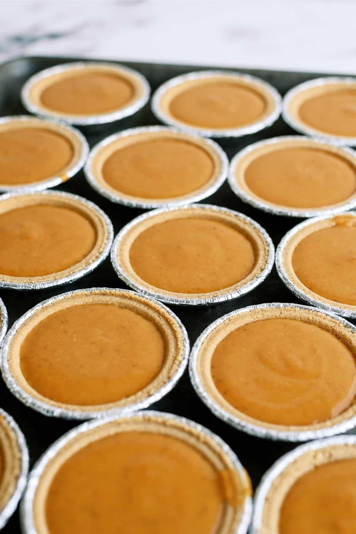 Mini Pumpkin Pies with Graham Cracker Crust on a sheet pan 