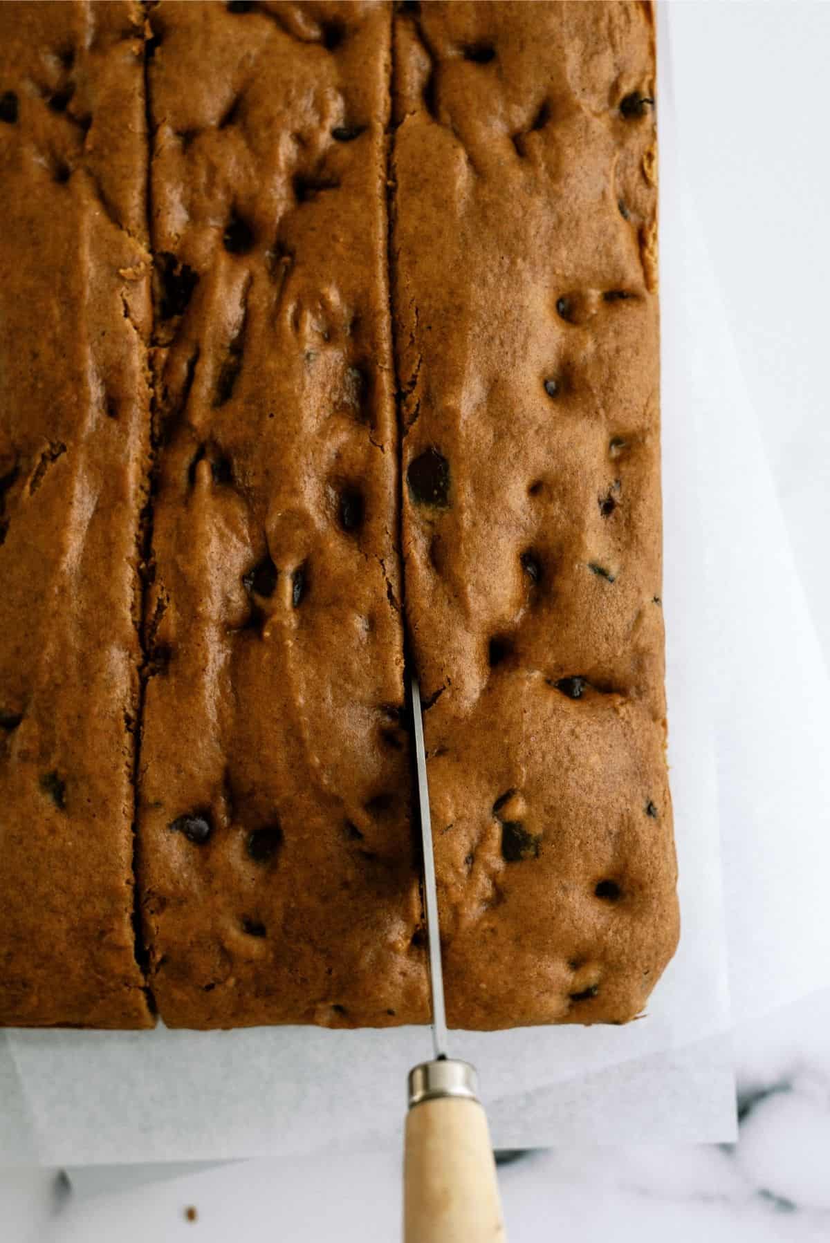 Pumpkin Chocolate Chip Brownies being cut into squares