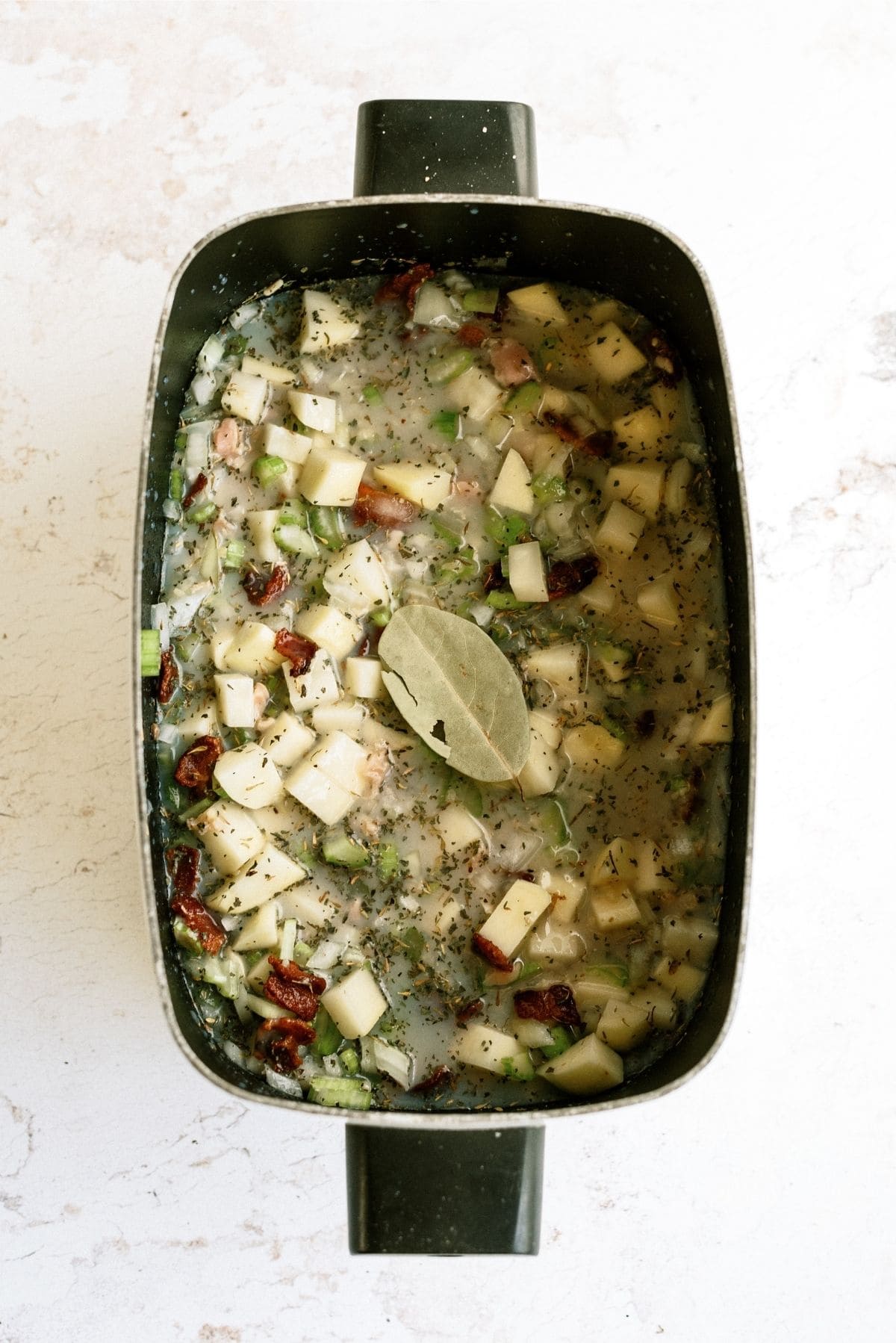 Slow Cooker filled with all the ingredients for Slow Cooker New England Clam Chowder