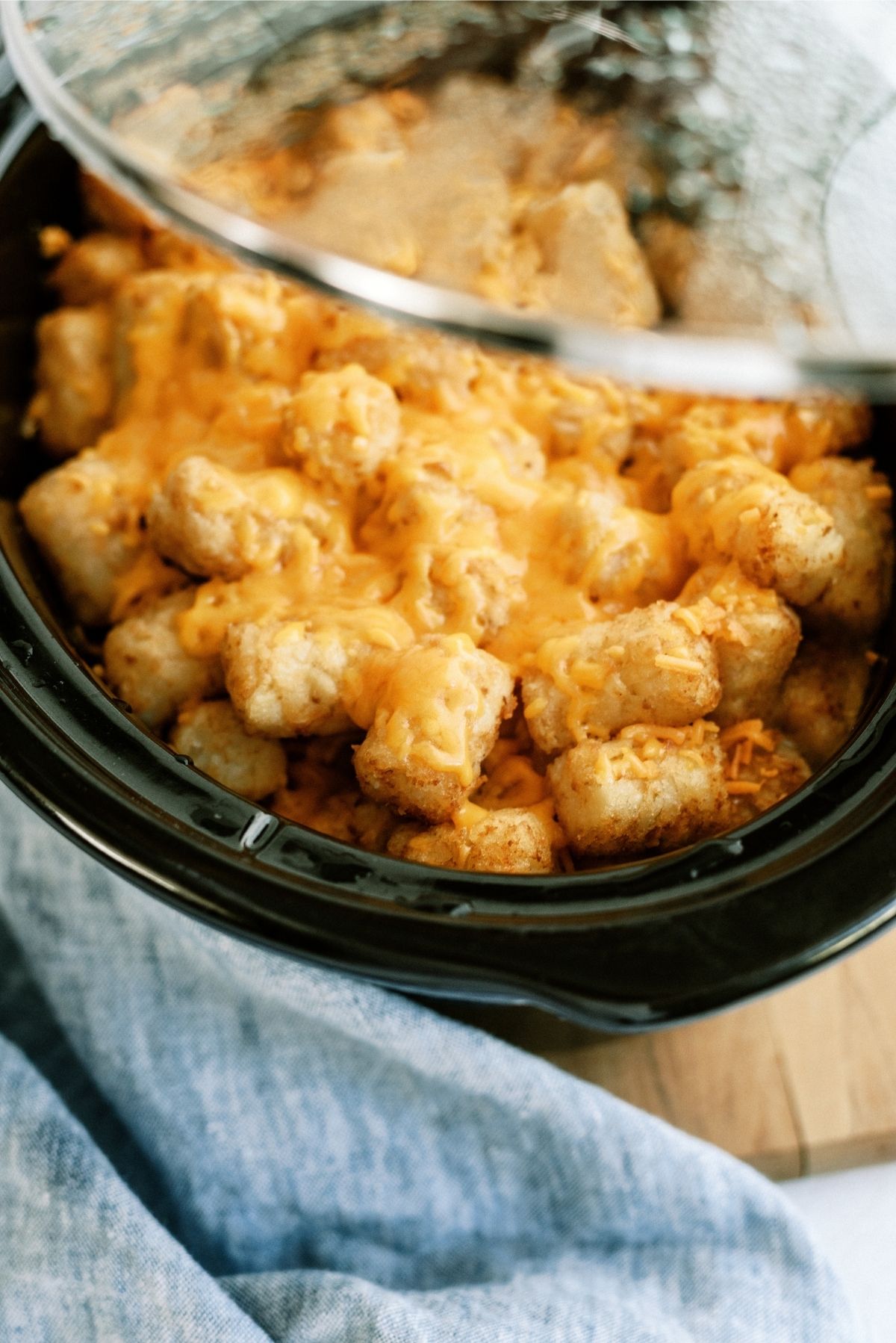 Slow Cooker Tater Tot Cowboy Casserole in the slow cooker with the lid partially lifted