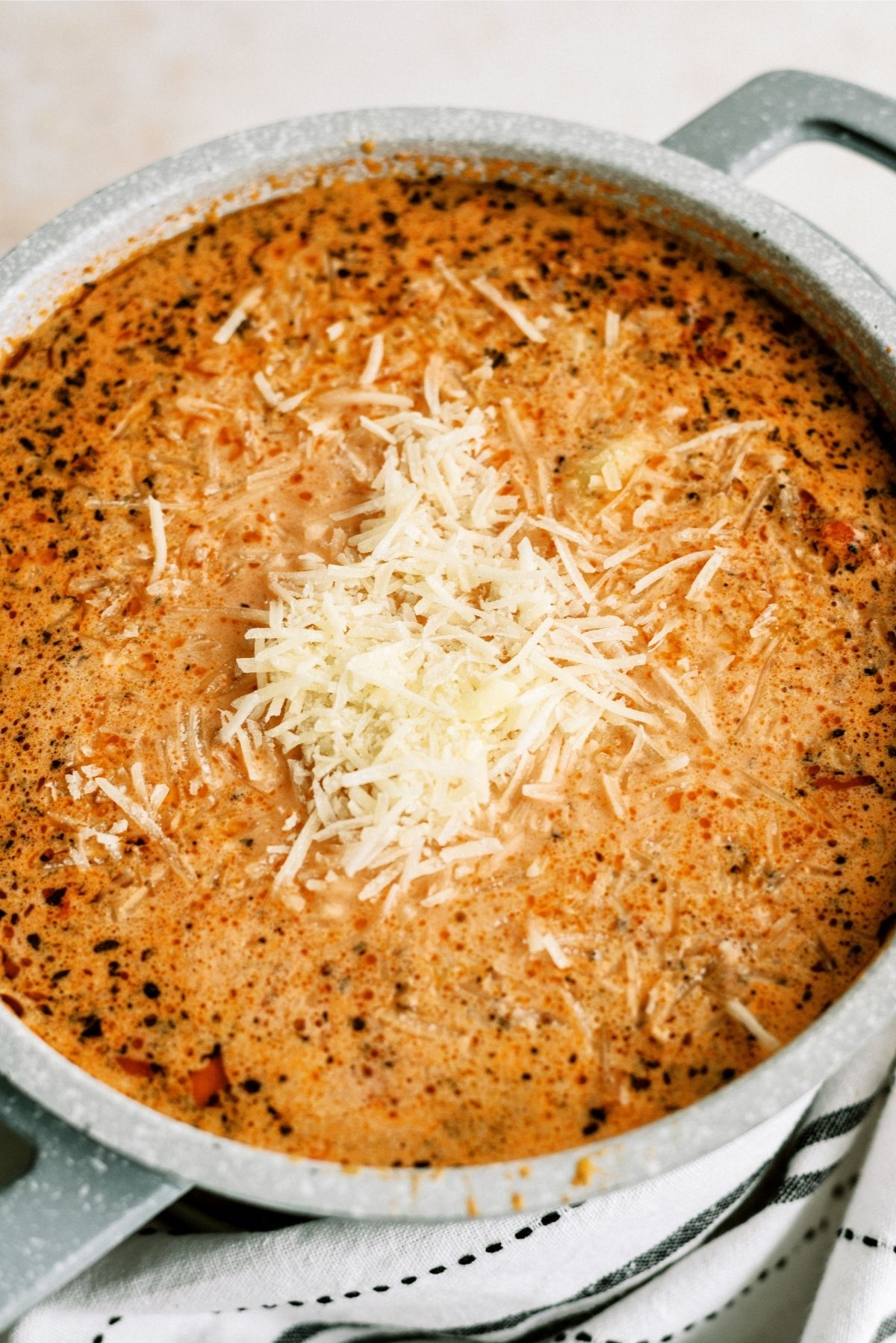Tomato Tortellini Soup topped with parmesan cheese in a stock pot