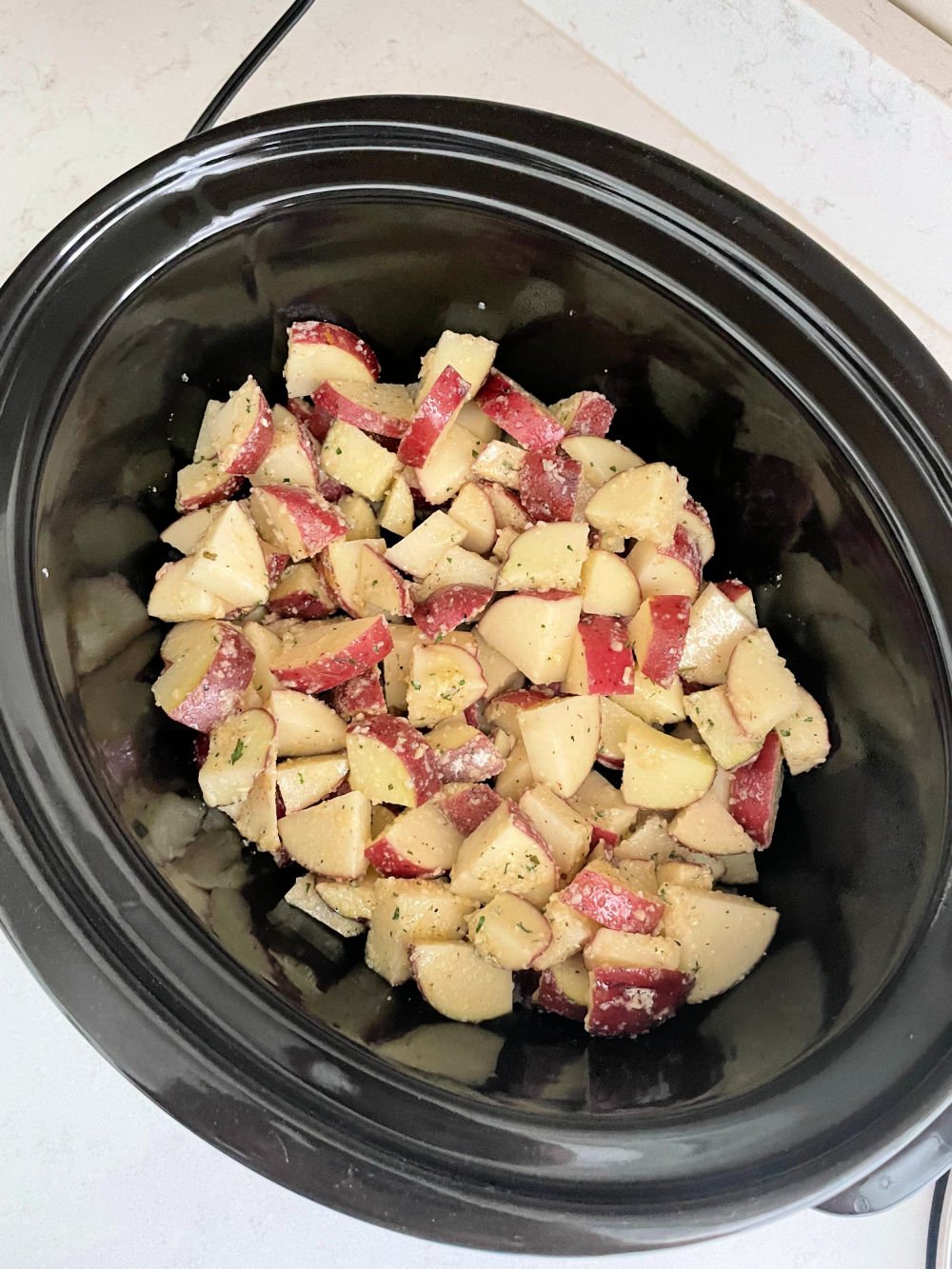 Cut and seasoned potatoes in slow cooker