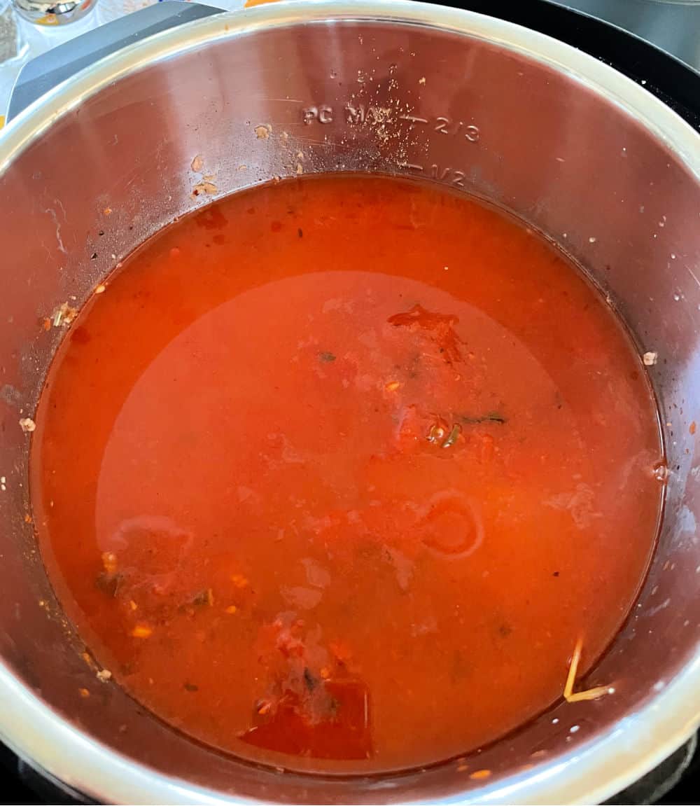 Spaghetti sauce added to Instant pot on top of noodles and beef