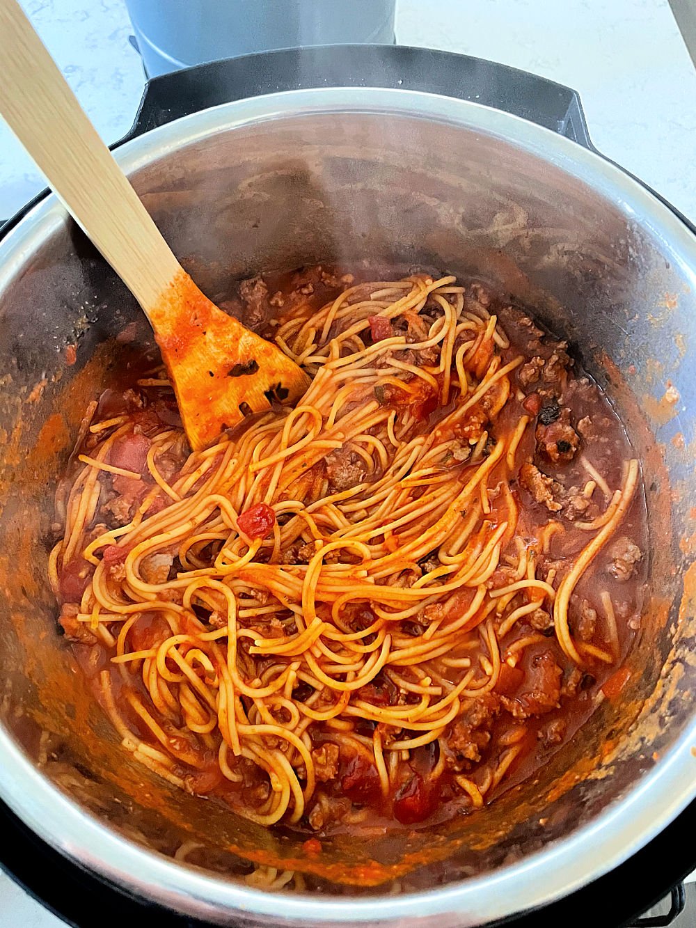 Instant Pot Creamy Spaghetti in an Instant Pot with a wooden spoon
