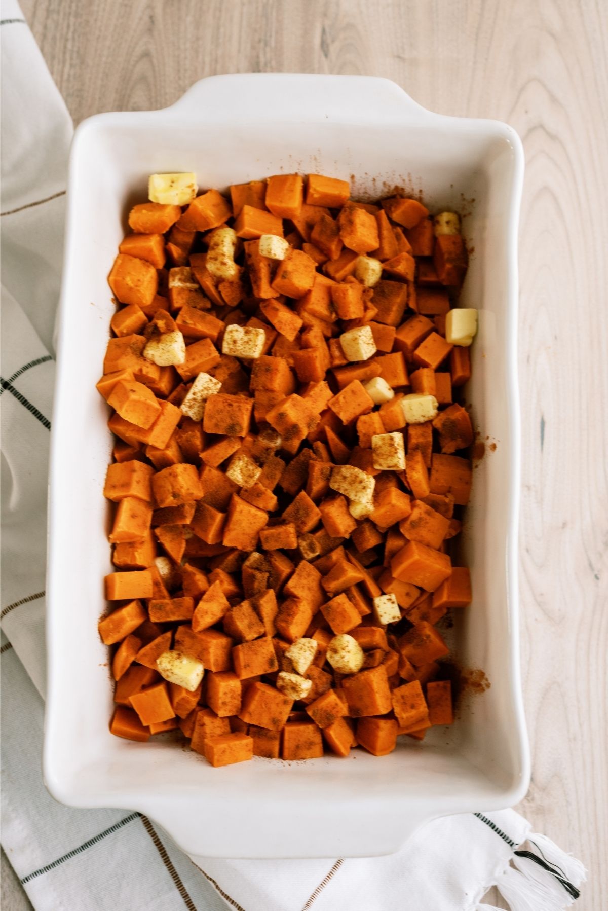 Cubed yams in 9x13 dish sprinkled with butter and cinnamon