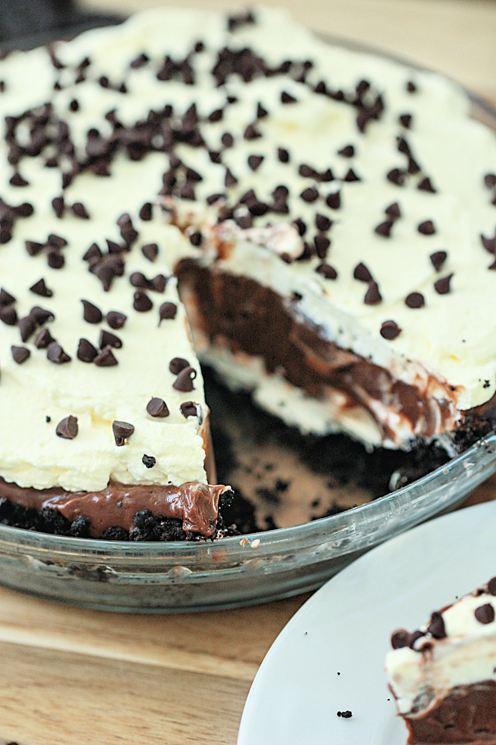 No Bake Chocolate Cream Pie in glass pie plate with one slice missing
