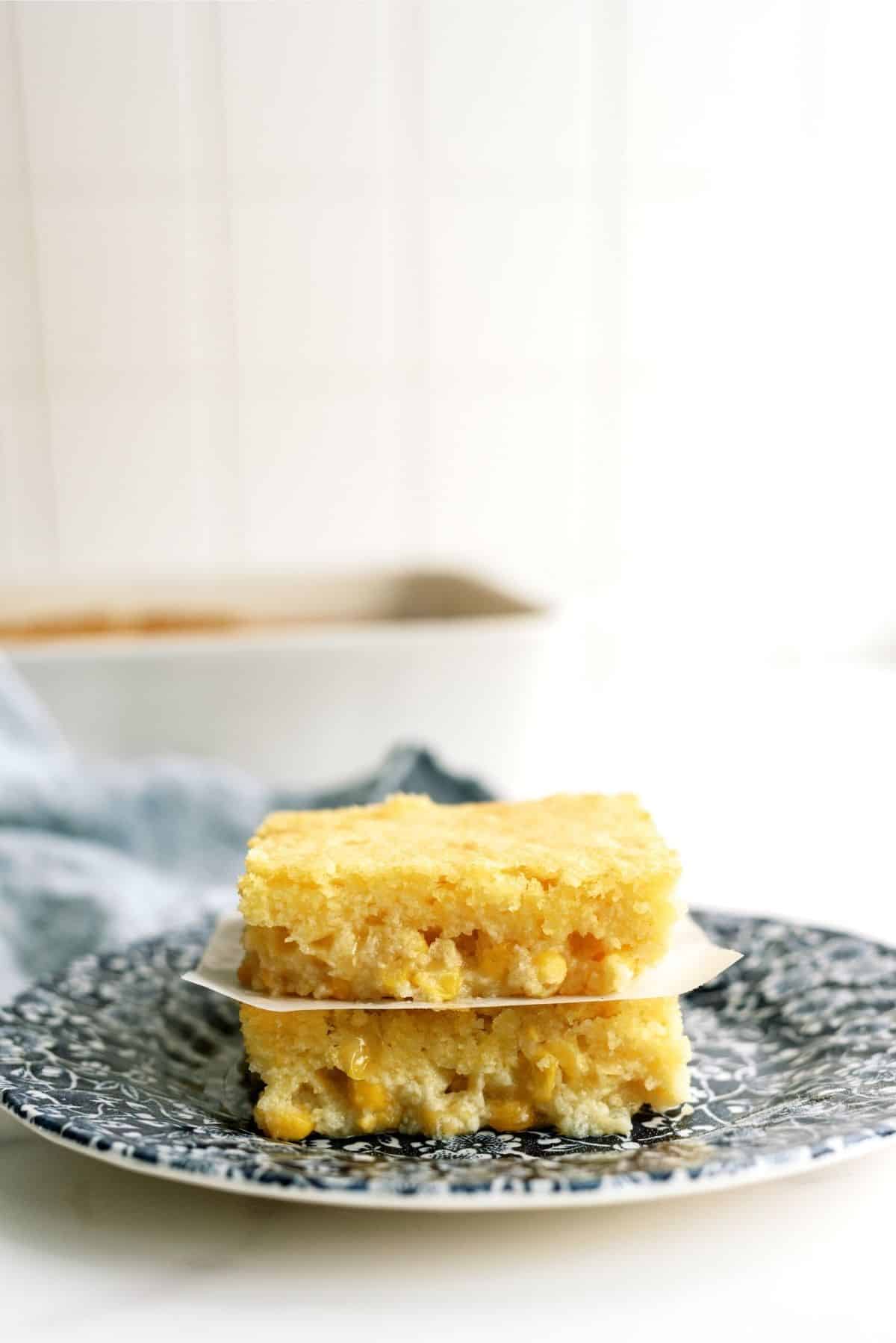 2 Slices of Corn Pudding Casserole stacked on a blue plate