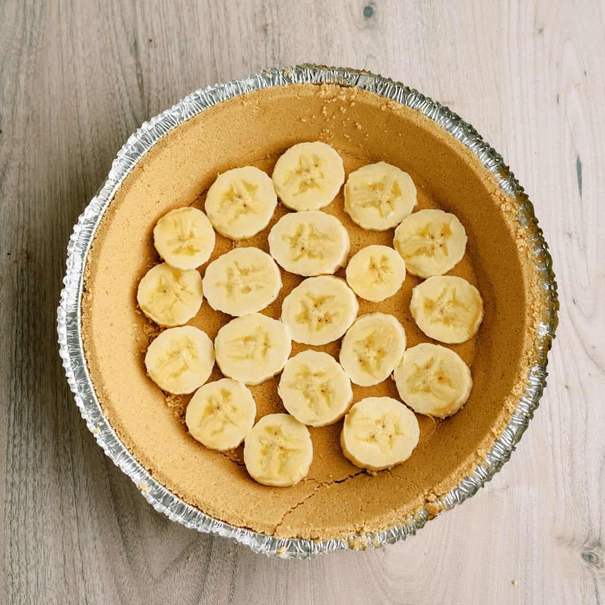 Premade Pie Crust with sliced bananas covering the bottom of the crust