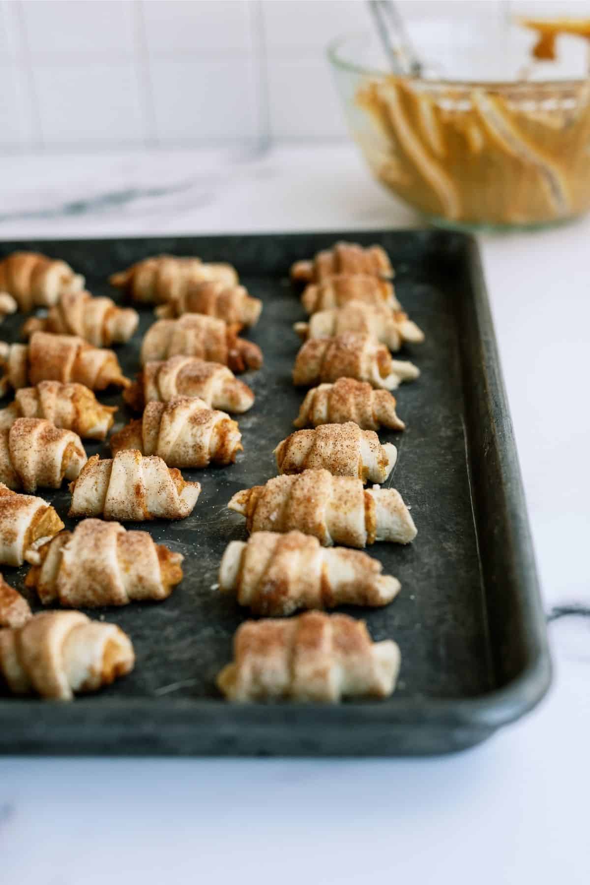 Unbaked Mini Pumpkin Pie Crescents on a sheet pan