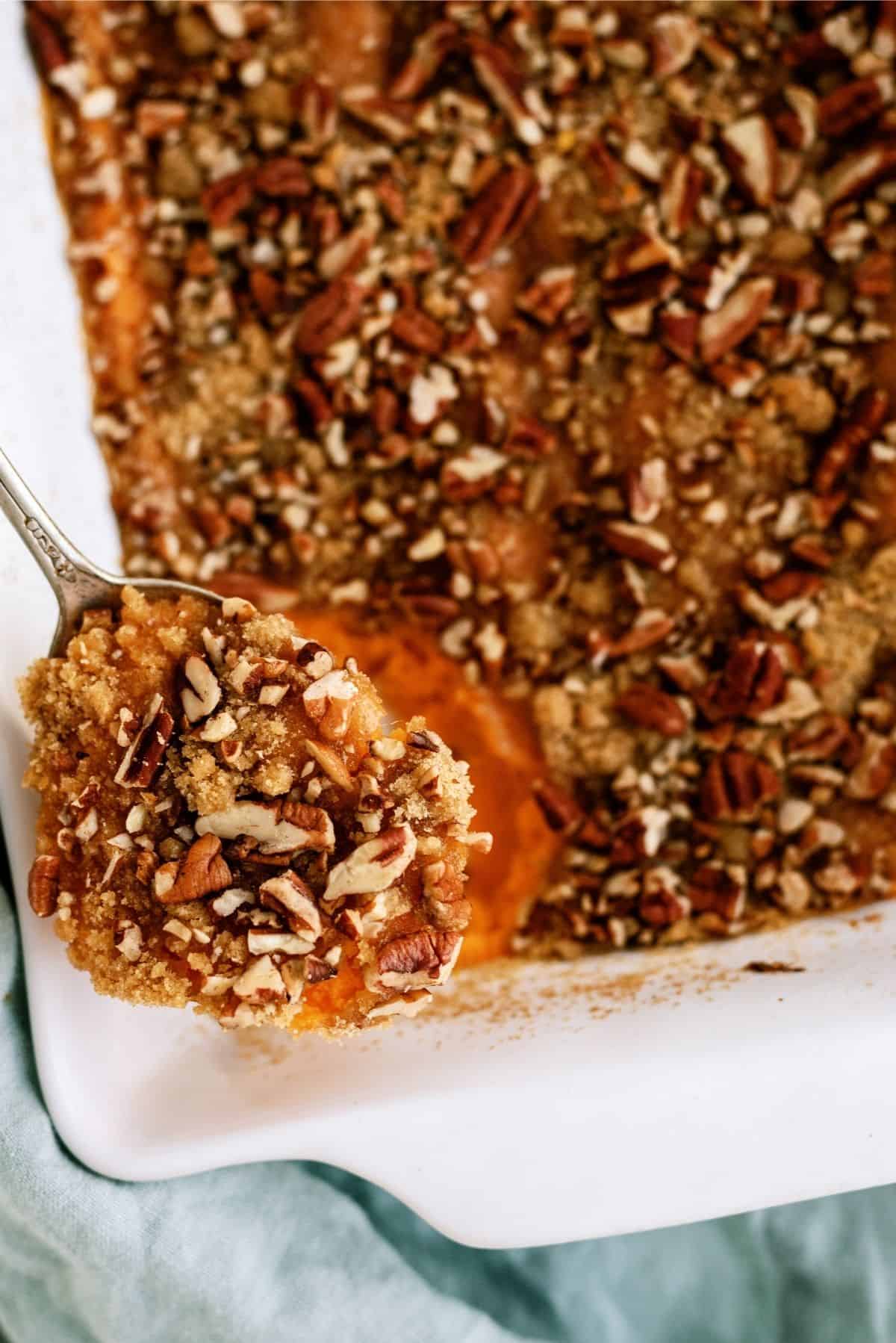 Mom’s Sweet Potato Casserole in a casserole dish with a spoon full of casserole