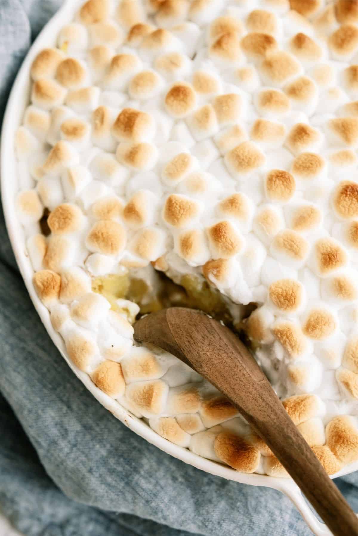 Mom’s Sweet Potatoes in a casserole dish with a wooden spoon