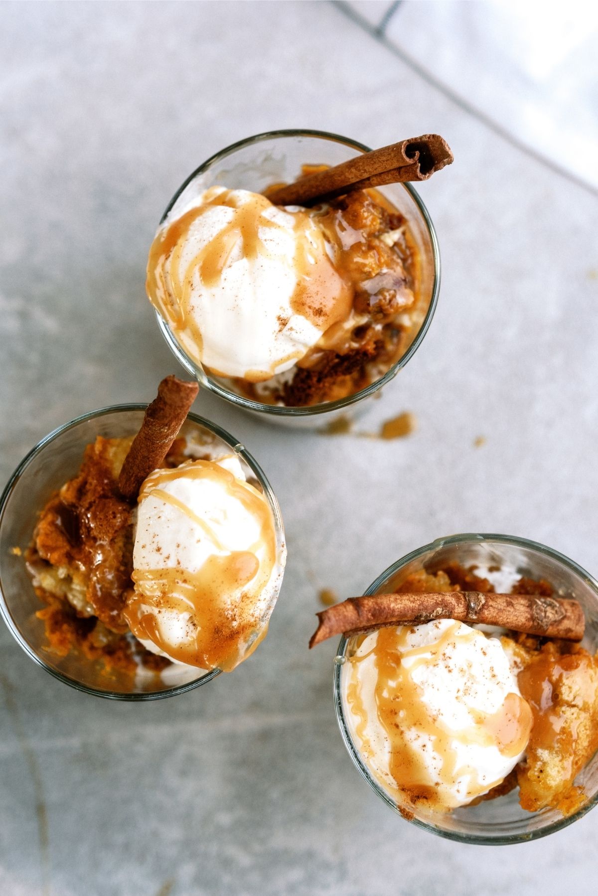 Pumpkin Pecan Cobbler in individual cups topped with ice cream and caramel sauce