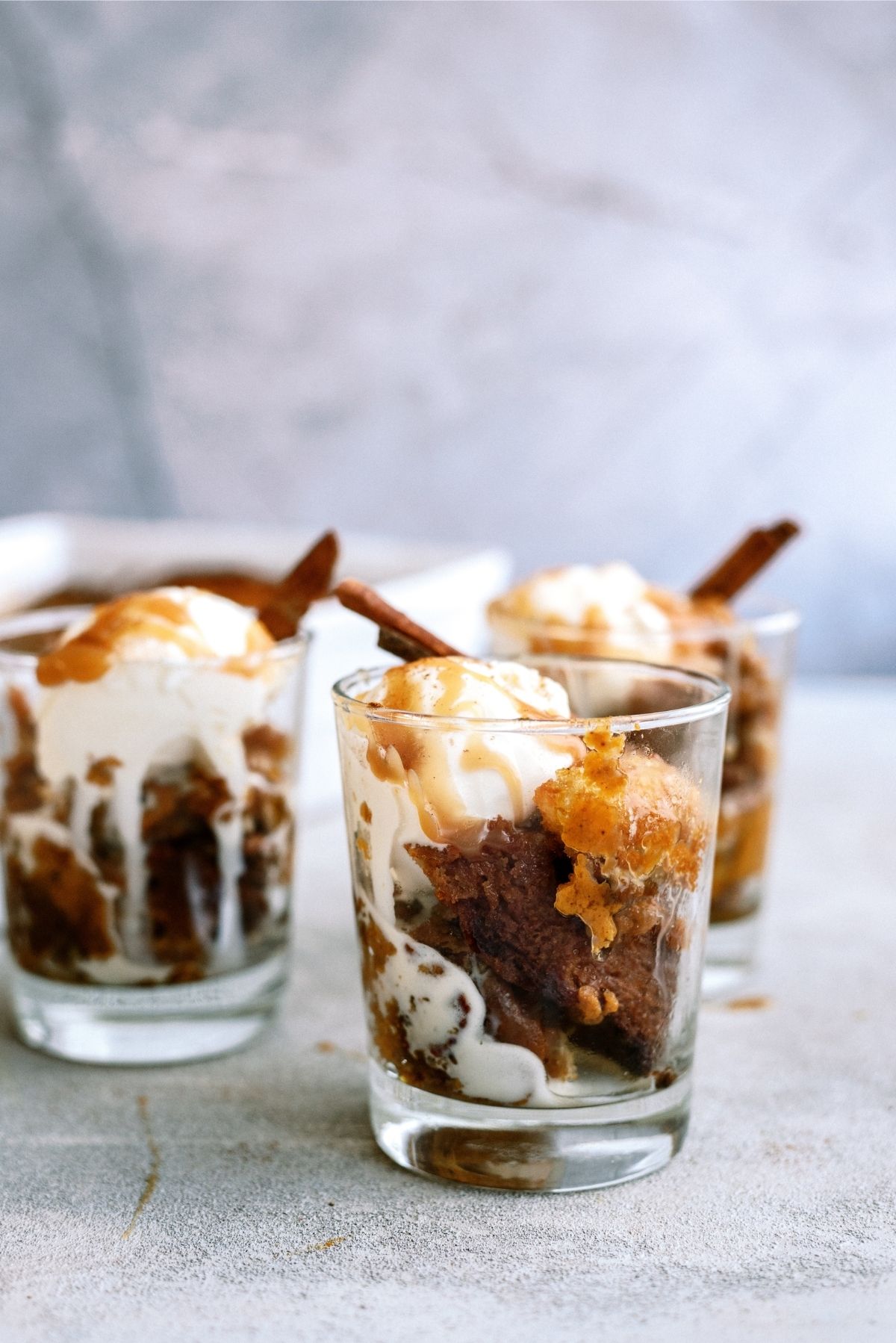 Pumpkin Pecan Cobbler in individual cups with ice cream and caramel sauce