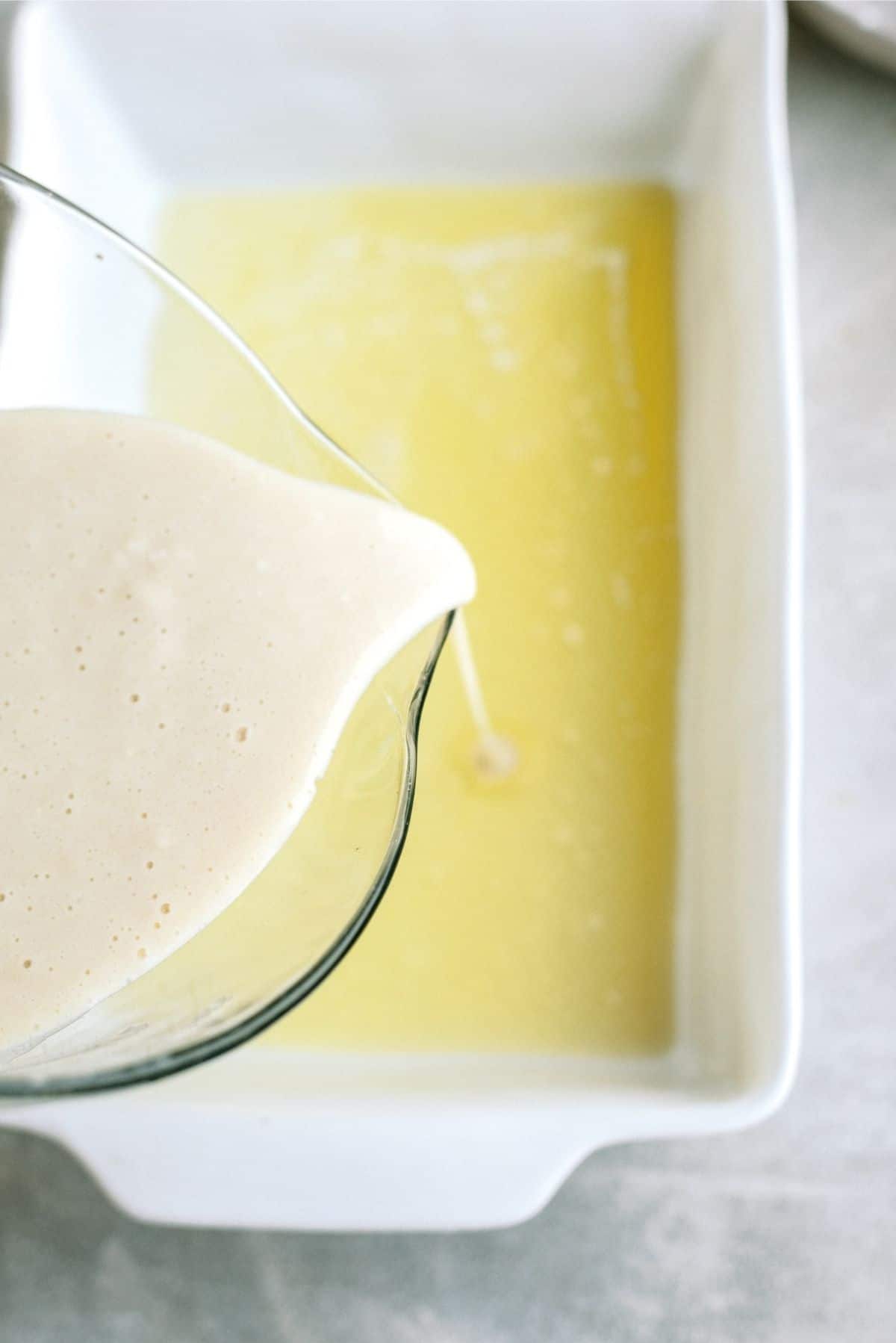 Milk and sugar mixture poured over to butter layer in 9x13 pan