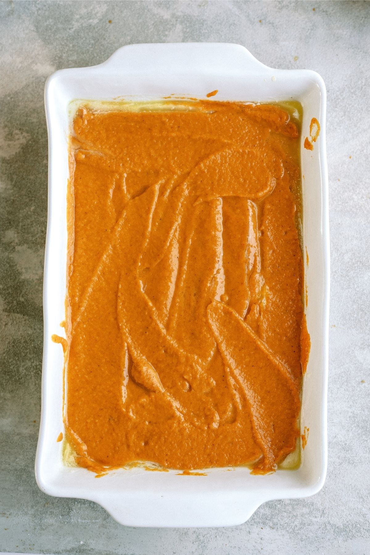 Pumpkin mixture layered on top of other layers in 9x13 pan