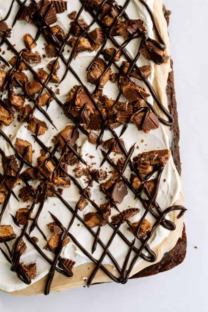Top view of Reese’s Peanut Butter Poke Cake with chocolate sauce drizzed on top.