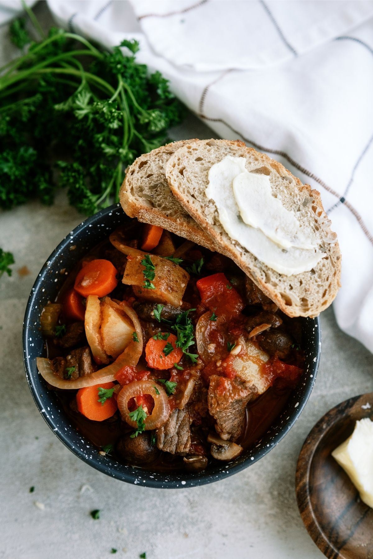 Slow Cooker Chunky Roast Stew in a bowl with a side of buttered bread