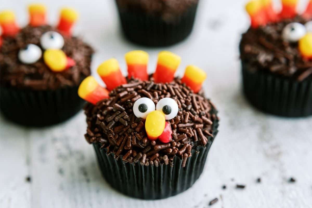 Chocolate cupcakes decorated with candy eyes, a beak, and candy corn to resemble turkeys.