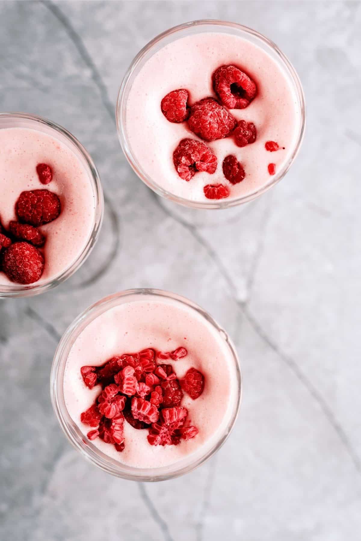 Grandma’s Frappe in glasses garnished with fresh raspberries