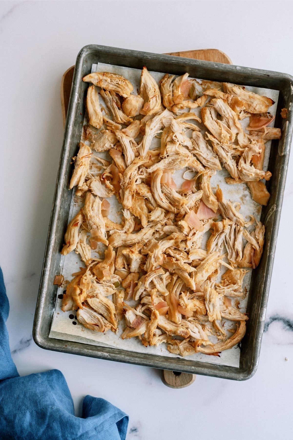 Shredded chicken spread out on a baking sheet