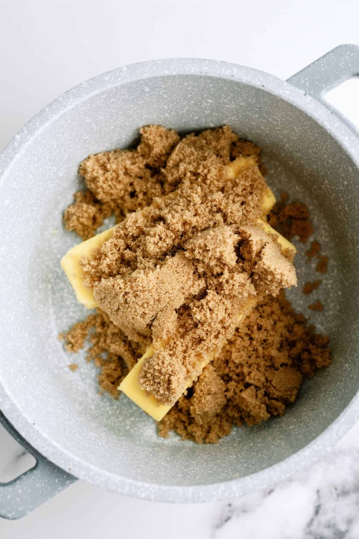 Medium saucepan with 2 sticks of butter and brown sugar inside.