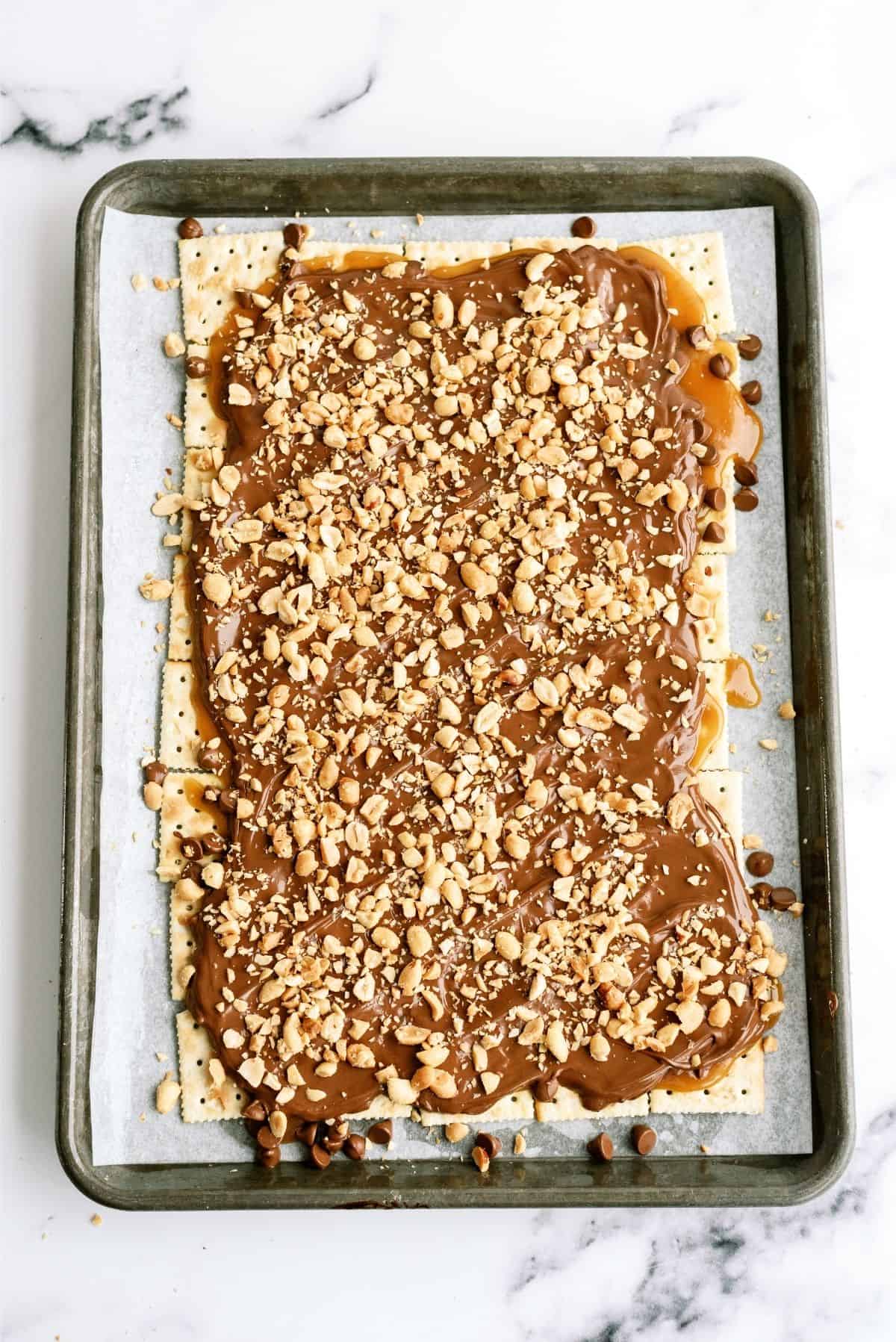 Chopped nuts sprinkled on top of other layers of Saltine Cracker English Toffee.