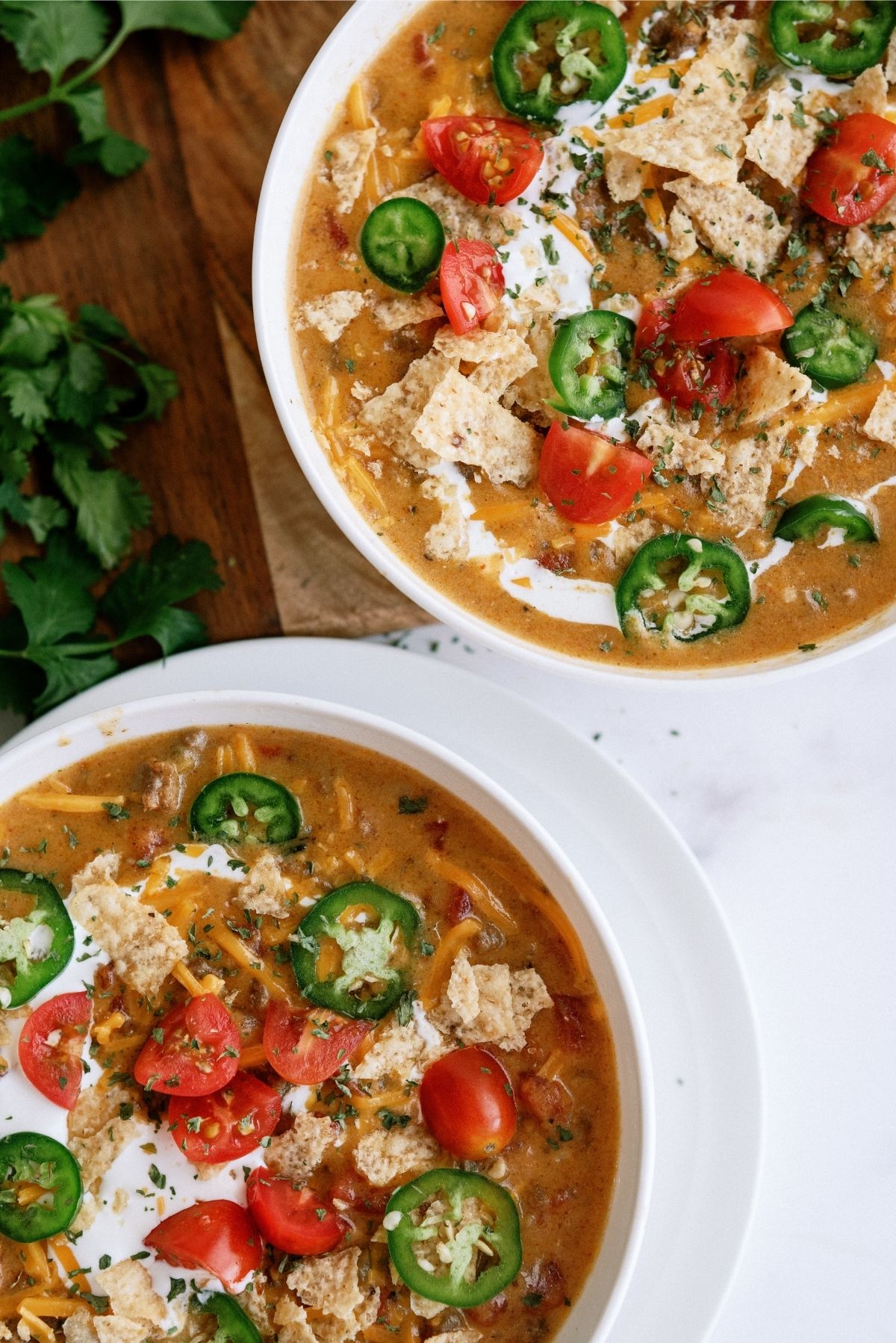 Slow Cooker Nacho Grande Soup in white bowls with toppings