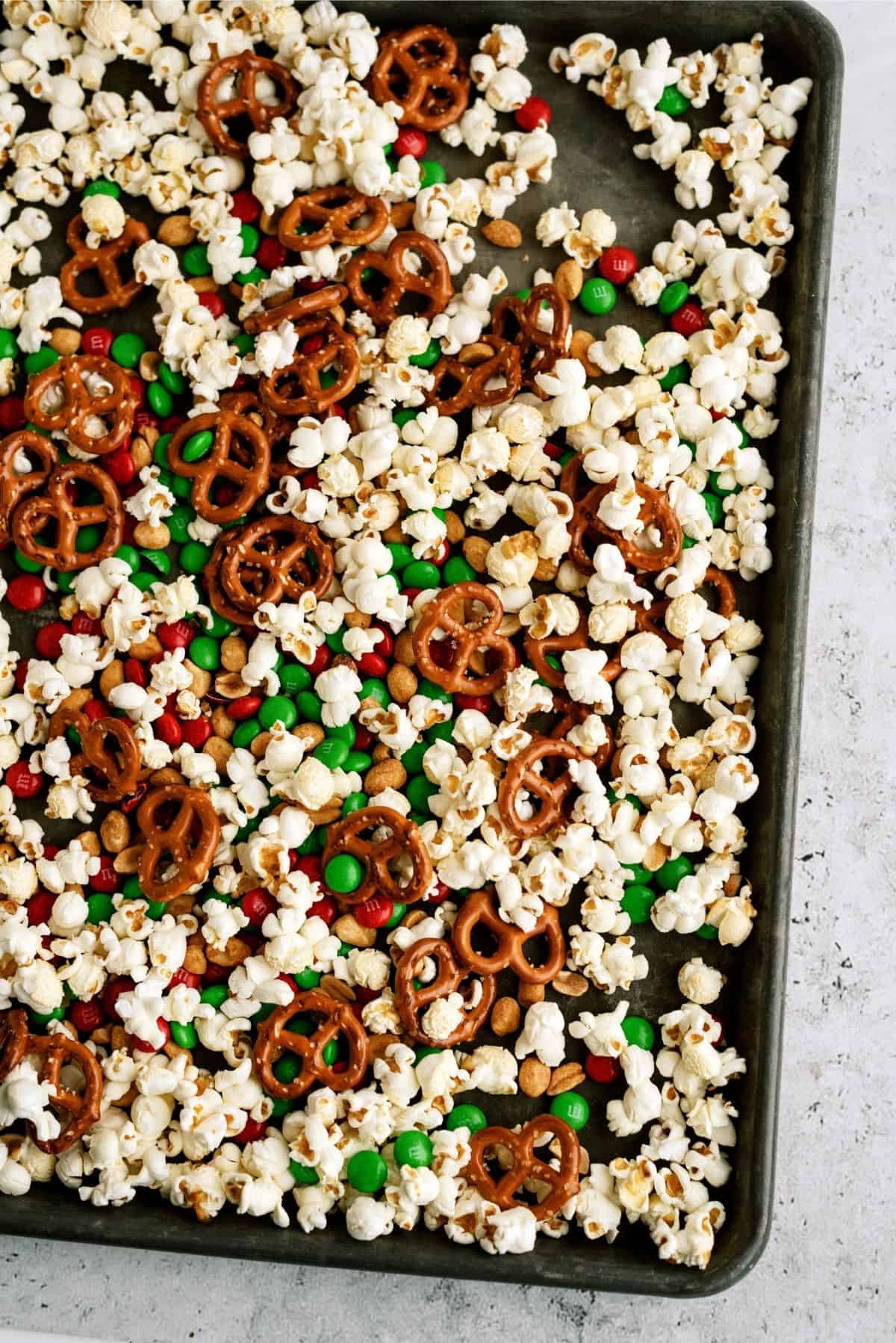 Popcorn mixture spread out on jelly roll pan