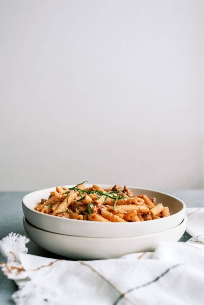 Side view of Creamy Sausage and Tomato Pasta in a white bowl.