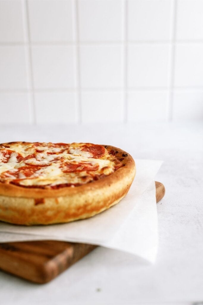 homemade deep dish pizza resting on a cutting board