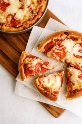 Homemade Pizza Hut Original Deep Dish Pizza sliced on a cutting board