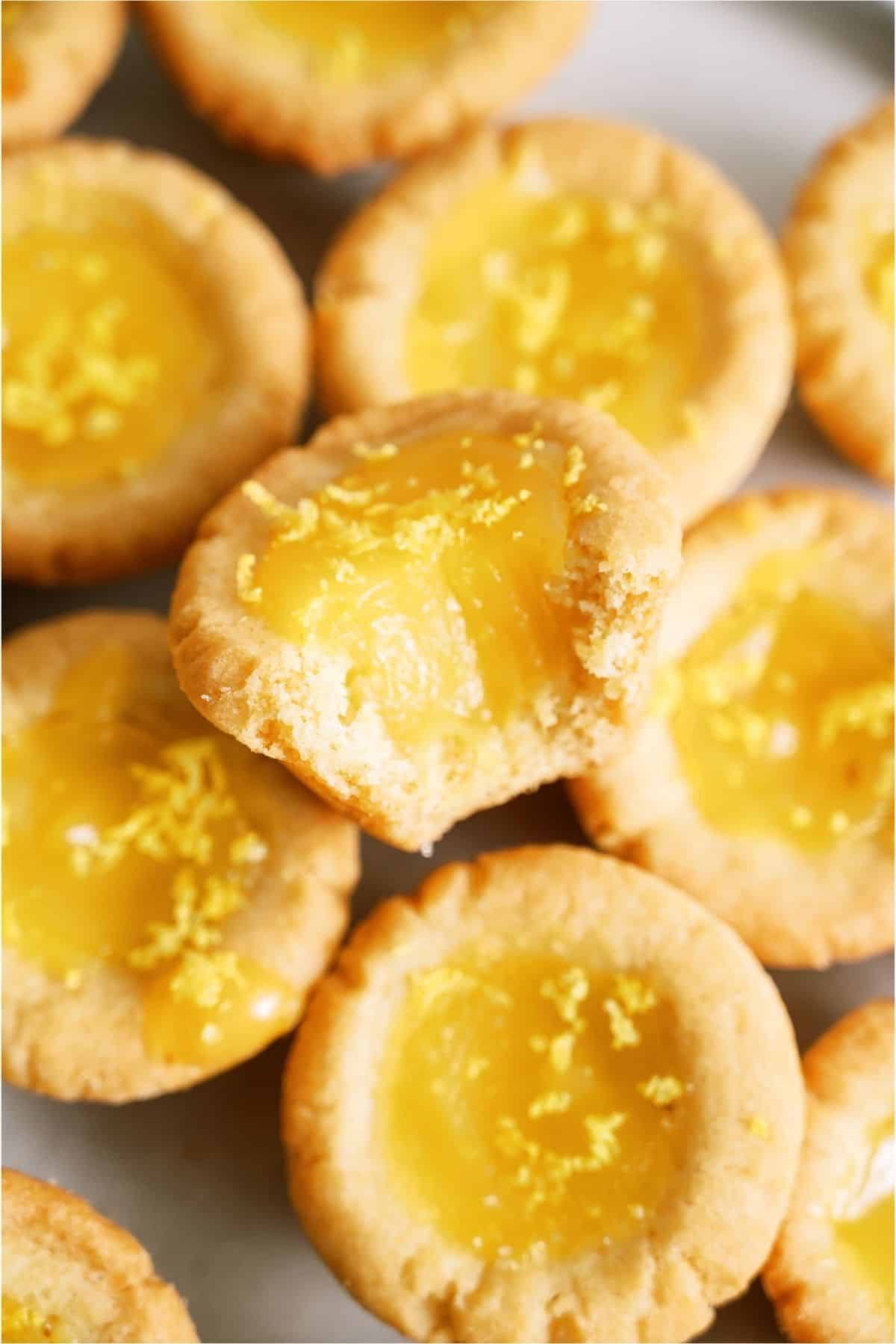 Several Lemon Bar Cookie Cups with one missing a bite.