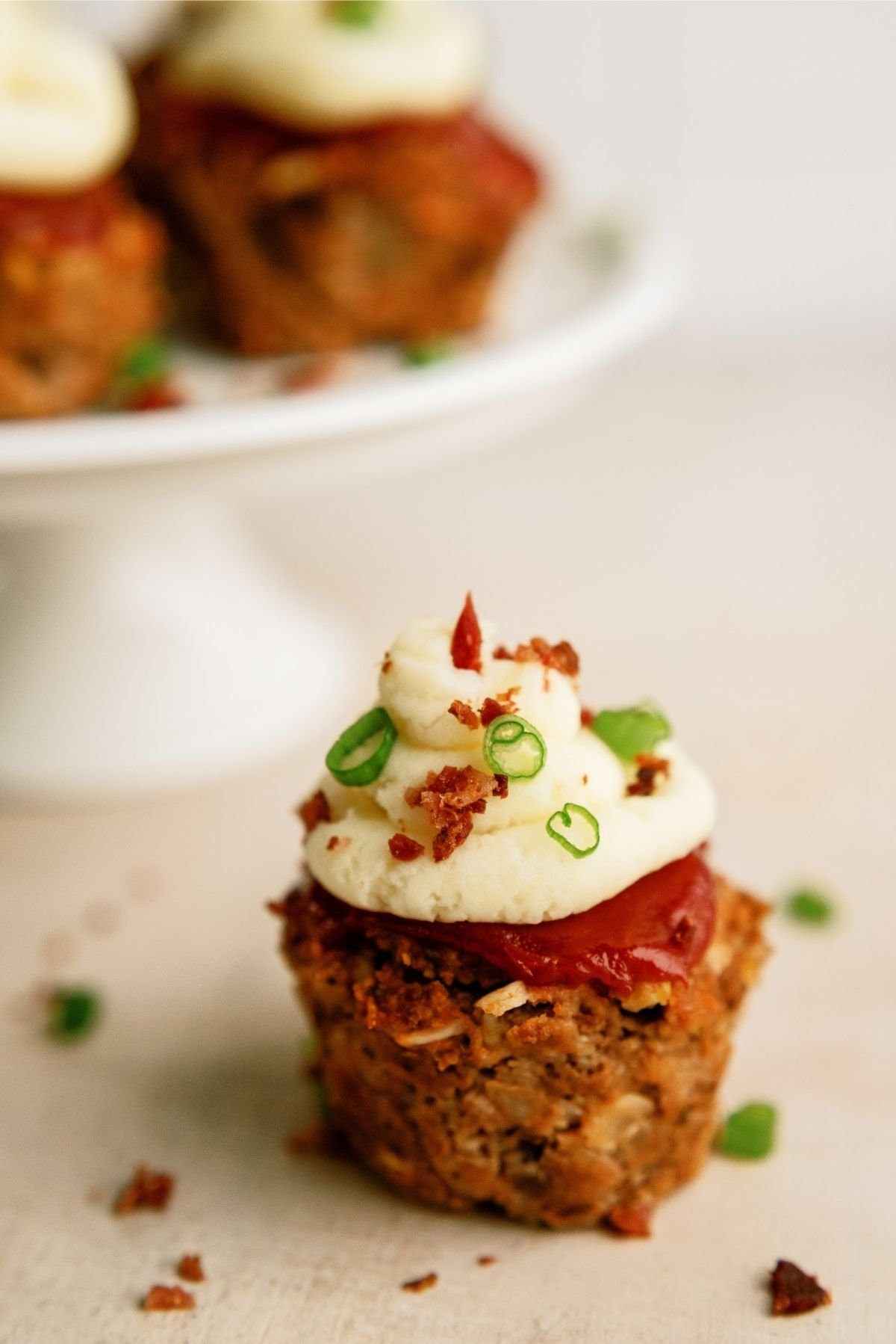 Meatloaf Cupcake on the counter with cake stand in the background
