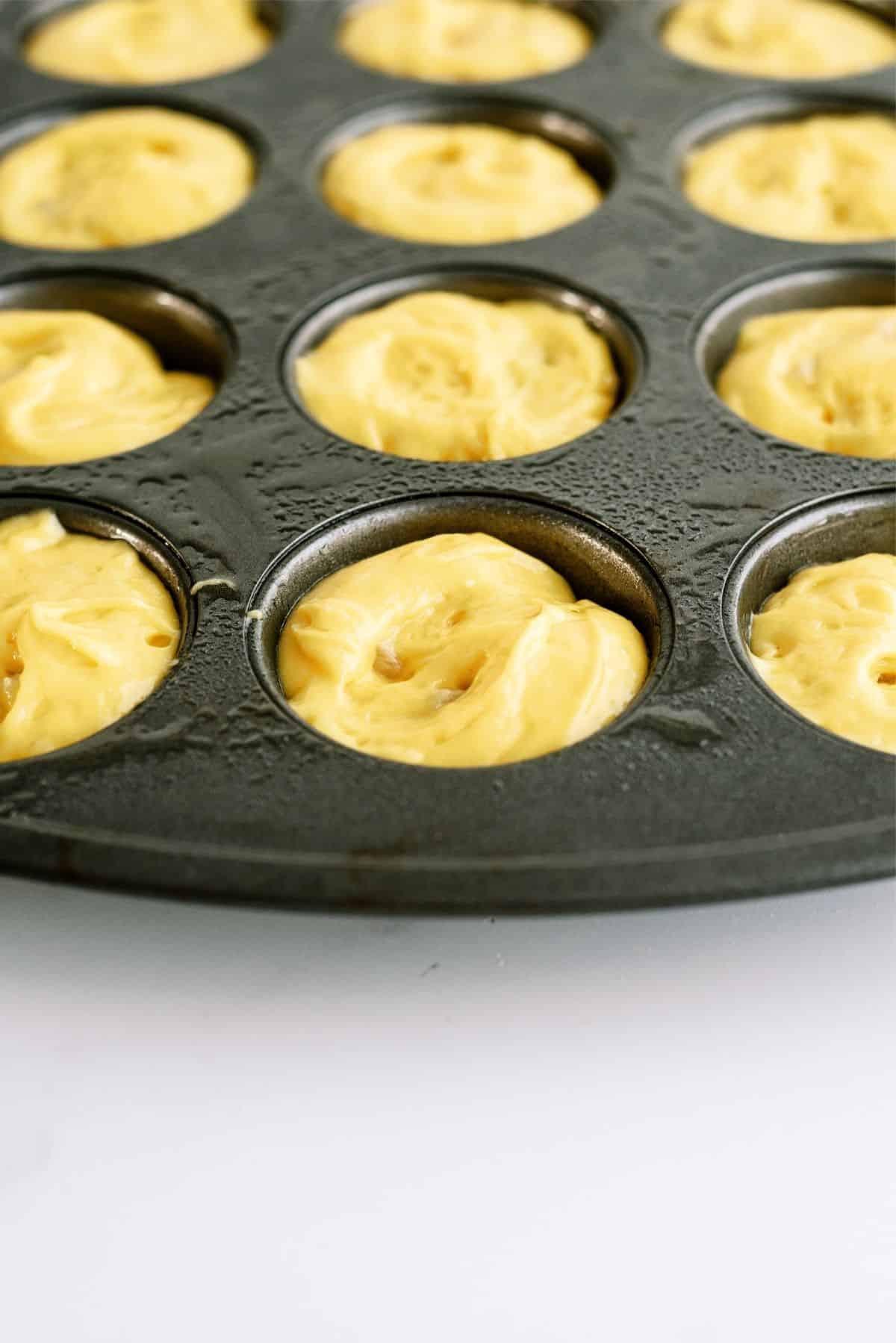 Unbaked Mini Pineapple Upside Down Cakes in muffin tin