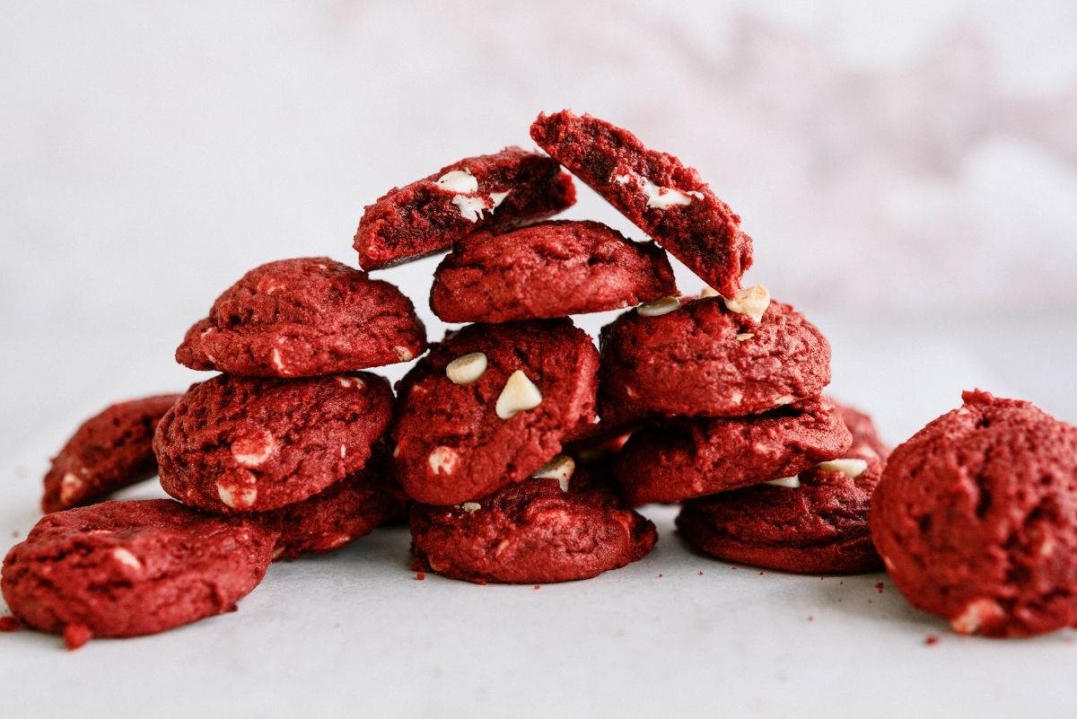 Red Velvet White Chocolate Chip Cookies stacked on a counter
