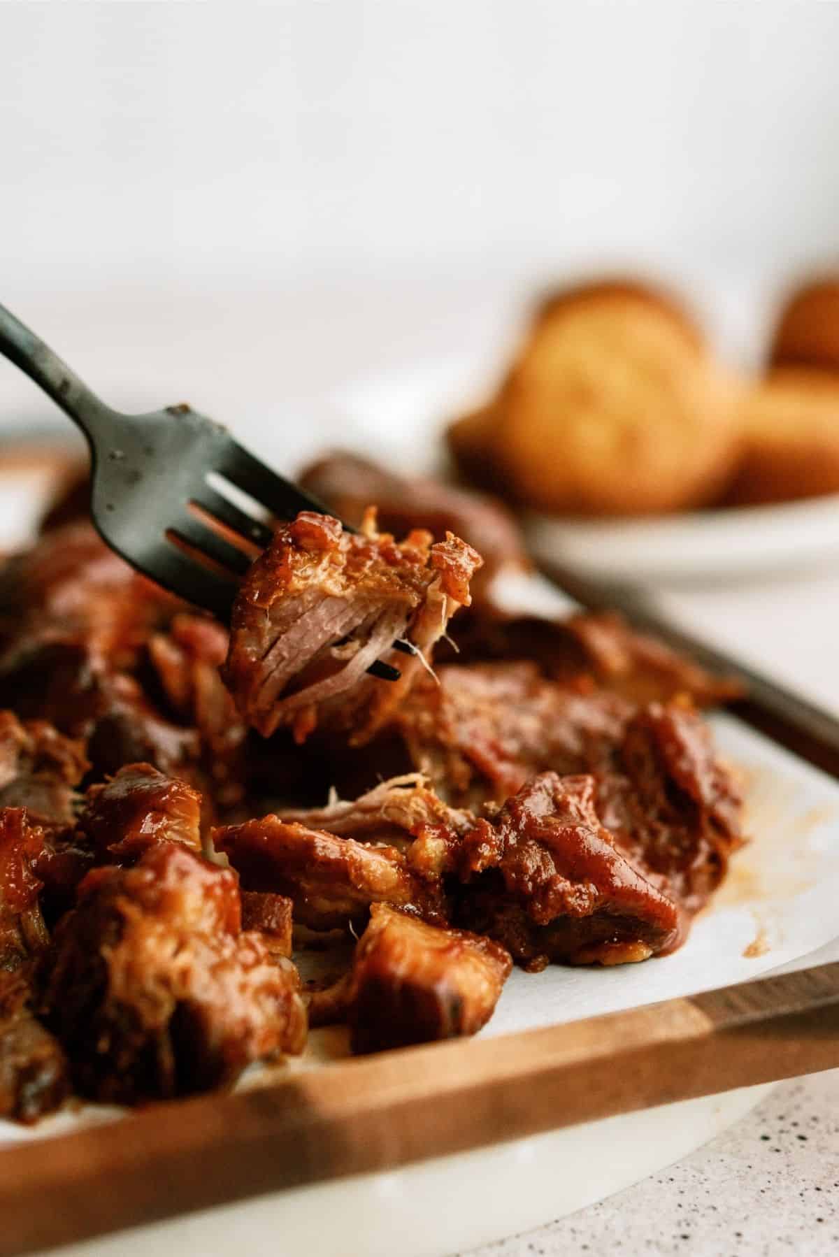 Slow Cooker BBQ Ranch Ribs on a cutting board with a fork