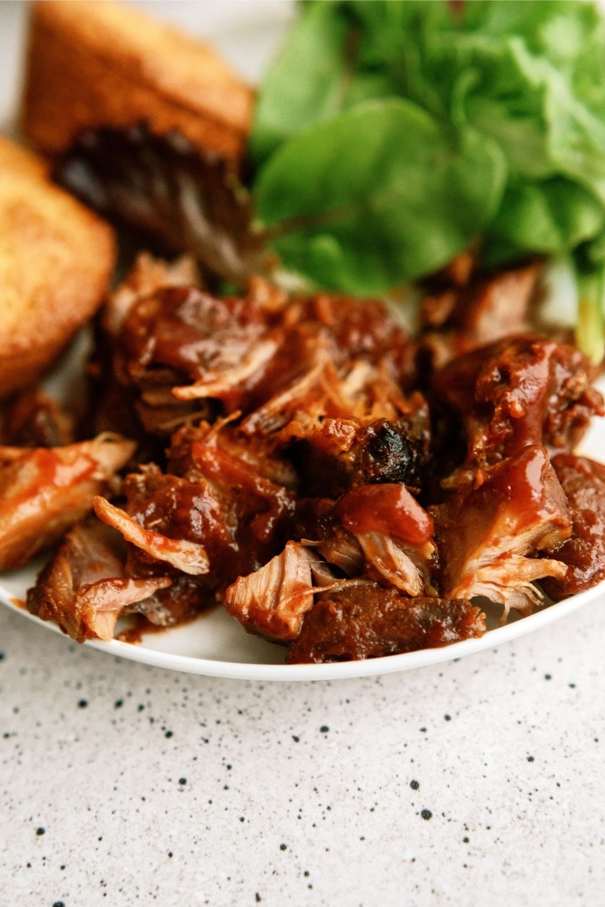 Slow Cooker BBQ Ranch Ribs on a plate with salad and bread