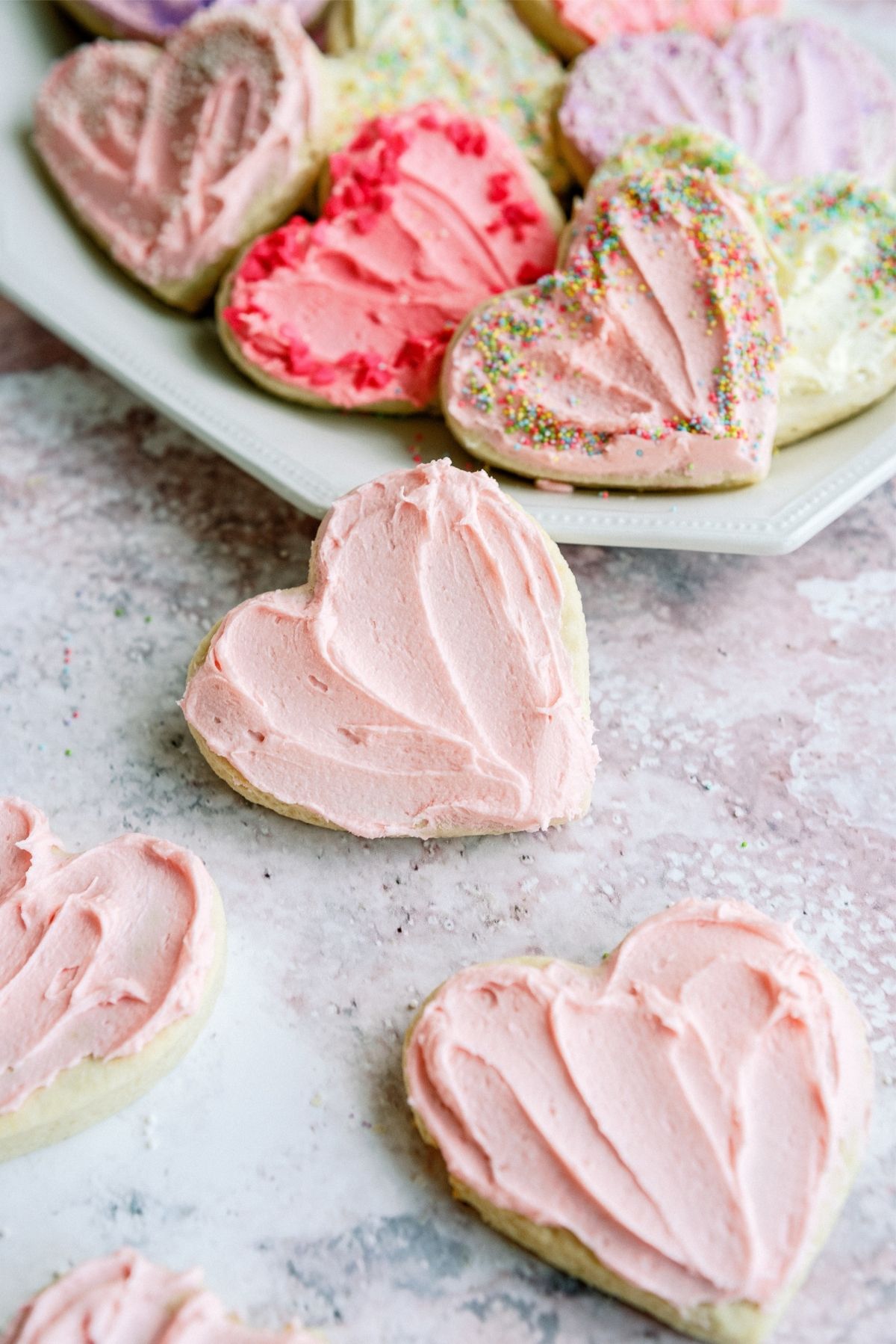 Valentine Sugar Cookies frosted on a counter and serving plate