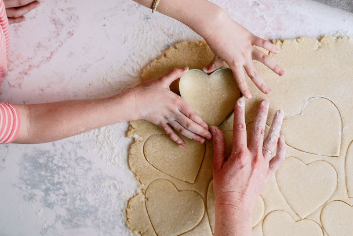 Using cookie cutters to cut out heart shaped dough