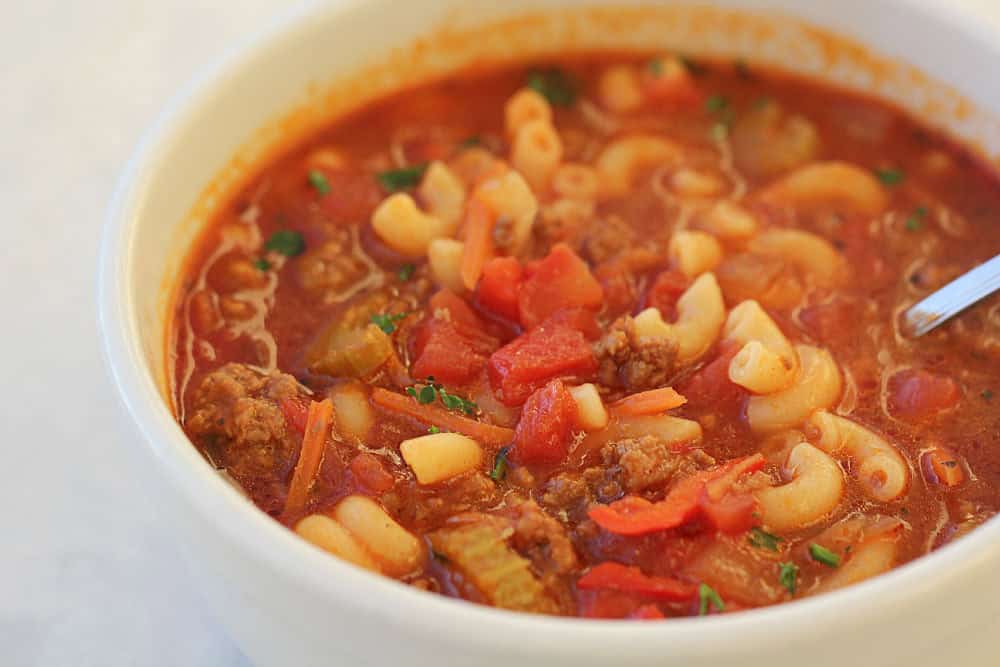 Tomato Macaroni Soup in a white bowl with a spoon