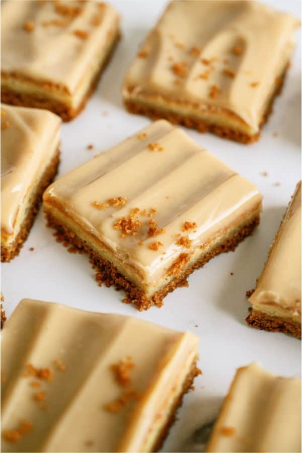 Caramel Cheesecake Bars cut into squares on a white background.